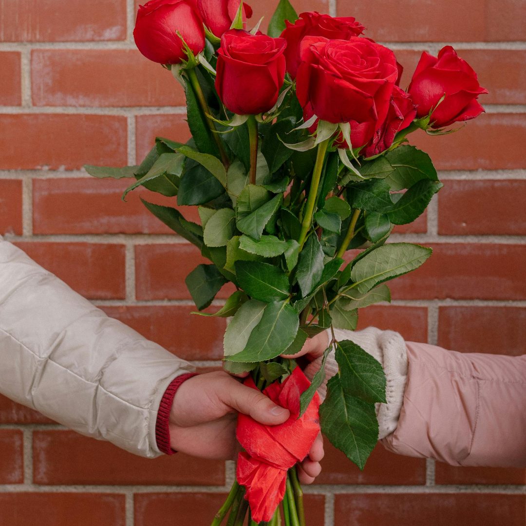 Pareja entregando ramo de rosas rojas como regalo de aniversario en Valencia