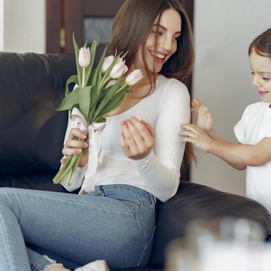 Niña entregando ramo de tulipanes a su madre en el Día de la Madre, regalo de Antea Flora Valencia